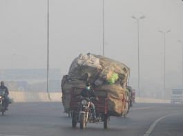 A man rides a motor tricycle, loaded with sacks of recyclables, amid dense smog in Lahore, Pakistan | File Photo: Reuters