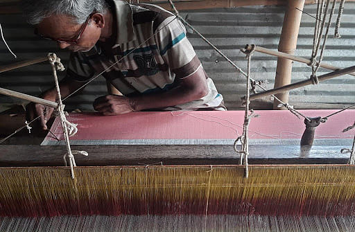 Thakur Ray, 60, from Upper Champahati embroiders the border of a silk sari