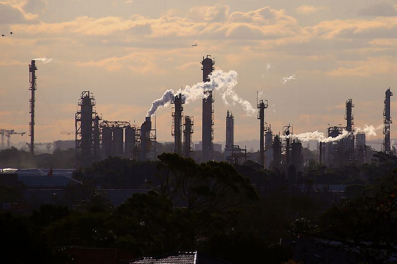 Birds and a plane are seen flying above emission from the chimneys of a chemical plant located near Port Botany in Sydney | File Photo: Reuters