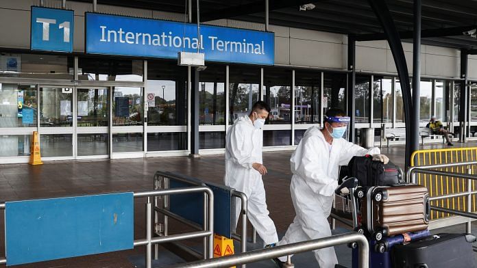 File photo of travellers in personal protective equipment depart the international terminal for a taxi stand at Sydney Airport| Photo: REUTERS