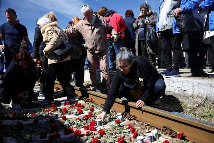 People leave candles and flowers on train tracks during a memorial marking the 80th anniversary of the first deportation of Jews from Thessaloniki to Auschwitz, in Thessaloniki, Greece on 19 March, 2023 | Reuters