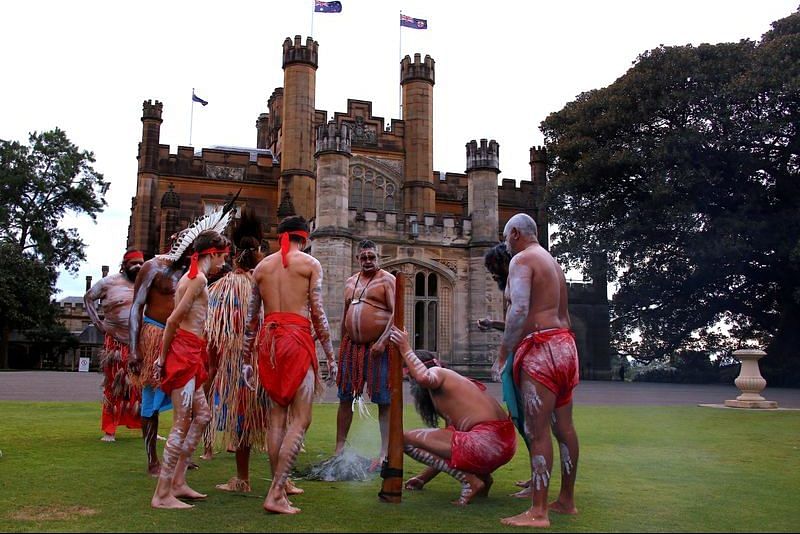 Australian Aborigines and Torres Strait Islanders wearing traditional dress stand in front of Government House after performing in a welcoming ceremony in Sydney | File Photo: Reuters