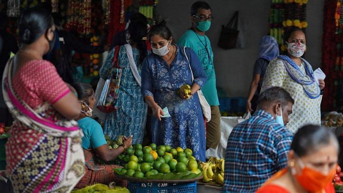 FILE PHOTO: A woman wearing a protective face mask buys fruit in a market, amidst the spread of the coronavirus disease (COVID-19) in Mumbai, India, August 20, 2020. REUTERS/Hemanshi Kamani