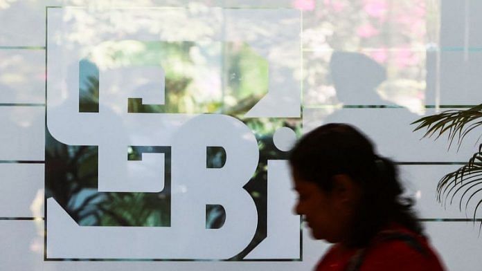A woman walks past the logo of the Securities and Exchange Board of India (SEBI), at its headquarters in Mumbai | File Photo: Reuters