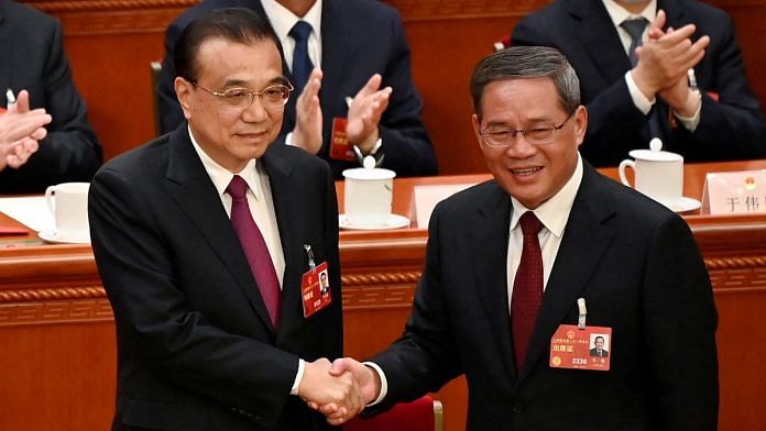 China's former Premier Li Keqiang shakes hands with newly elected Premier Li Qiang during the fourth plenary session of the National People's Congress (NPC) at the Great Hall of the People in Beijing, China on March 11, 2023. GREG BAKER/Pool via REUTERS
