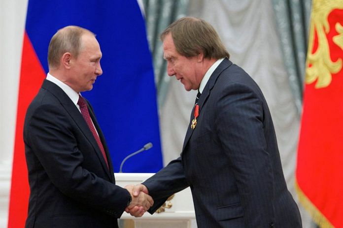 FILE PHOTO: Russian President Vladimir Putin (L) shakes hands with artistic director of St. Petersburg House of Music Sergei Roldugin after awarding him during a ceremony at the Kremlin in Moscow, Russia, September 22, 2016. REUTERS/Ivan Sekretarev/Pool/File Photo