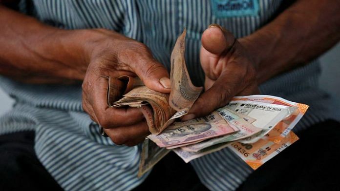 An attendant at a fuel station arranges Indian rupee notes in Kolkata | File Photo