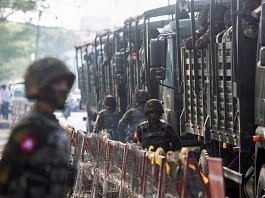 Soldiers stand next to military vehicles as people gather to protest against the military coup, in Yangon, Myanmar | File Photo: Reuters