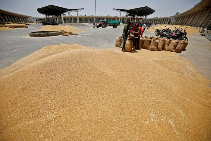 Workers fill sacks with wheat at the market yard of the Agriculture Product Marketing Committee (APMC) on the outskirts of Ahmedabad | File Photo: Reuters