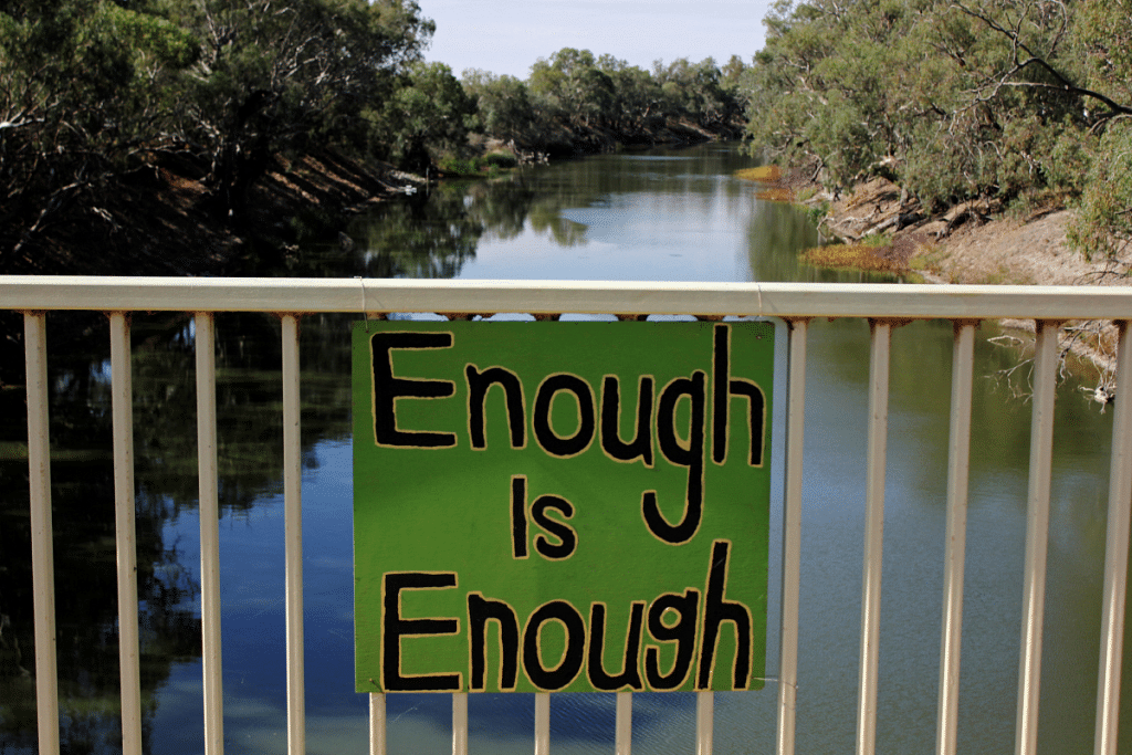 A sign protesting against government management of water allocation on a bridge over the drying-up Darling River at Menindee in Australia | File photo/Reuters
