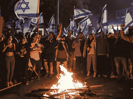 Israeli protesters chant in front of a burning fire at a demonstration against Israeli Prime Minister Benjamin Netanyahu and his nationalist coalition government's plan for judicial overhaul, in Tel Aviv | Reuters