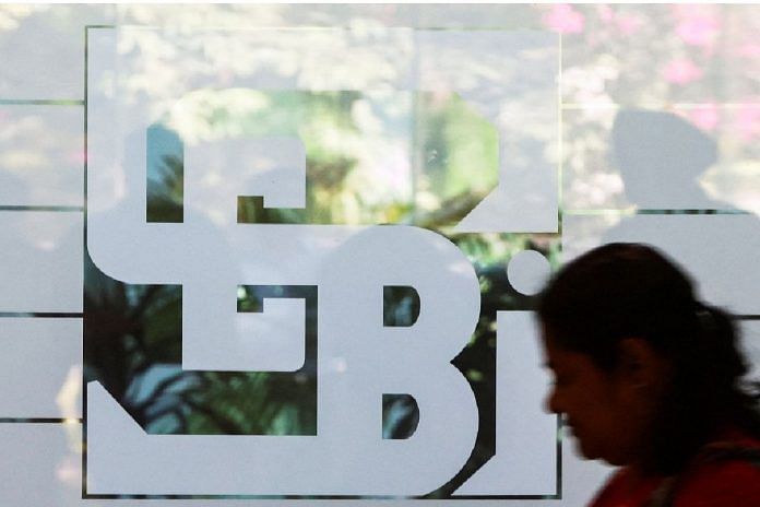A woman walks past the logo of the Securities and Exchange Board of India (SEBI), at its headquarters in Mumbai | Reuters
