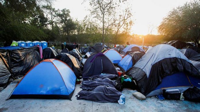 Migrants who are seeking asylum in the United States rest as they wait at a makeshift encampment near the border between the U.S. and Mexico, in Matamoros, Mexico | File Photo: Reuters