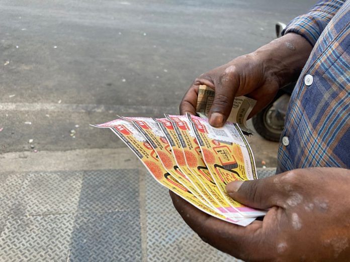 A man holds colourful lottery tickets in Kerala | Photo: Vandana Menon/ThePrint