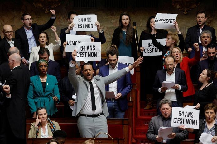 Members of parliament of the left hold placards in protests against the bill at the National Assembly in Paris, on 16 March 2023 | Reuters