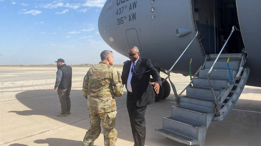 U.S. Defense Secretary Lloyd Austin is greeted next to a plane by Major General Matthew McFarlane, during his unannounced trip to Baghdad, Iraq, March 7, 2023. REUTERS/Idrees Ali