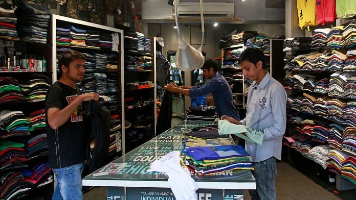 File photo of salesmen folding shirts inside a clothes store at a market in Mumbai, 3 March 2016| Reuters/Danish Siddiqui