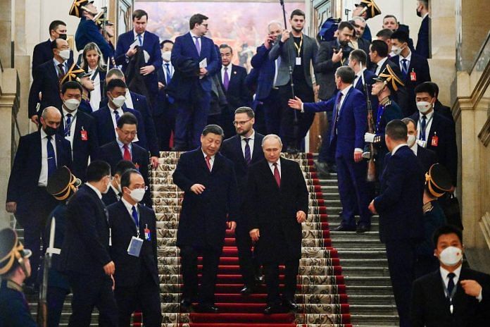 Russian President Vladimir Putin and Chinese President Xi Jinping leave after a reception in honor of Xi's visit to Moscow, on 21 March 2023 | Sputnik/Pavel Byrkin/Kremlin via Reuters
