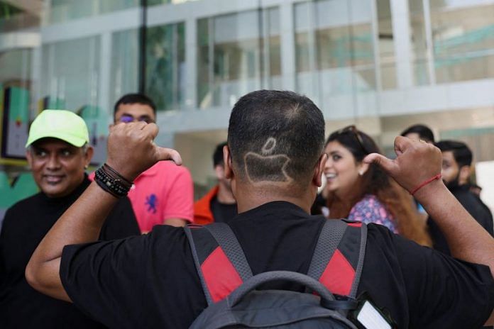 Apoorv Rao, an Apple fan from Bangalore, sports a haircut depicting the Apple logo as he waits in a queue outside India's first Apple retail store on the day of its opening in Mumbai, on 18 April 2023 | Reuters