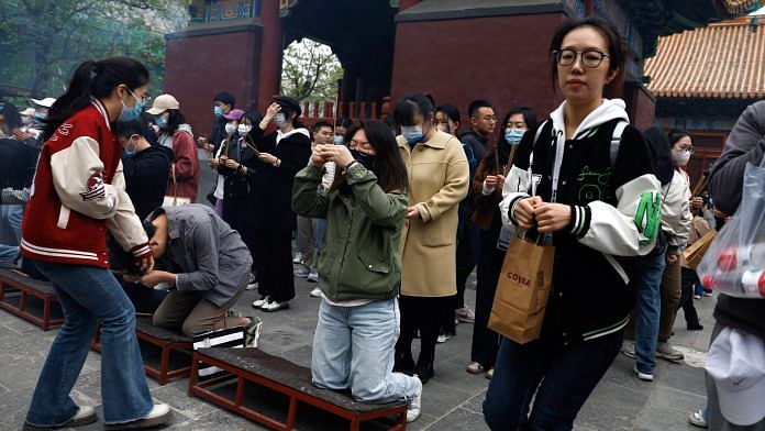 People burn incense sticks to pray for good fortune at Lama Temple, in Beijing on 22 April 2023 | Photo: Reuters