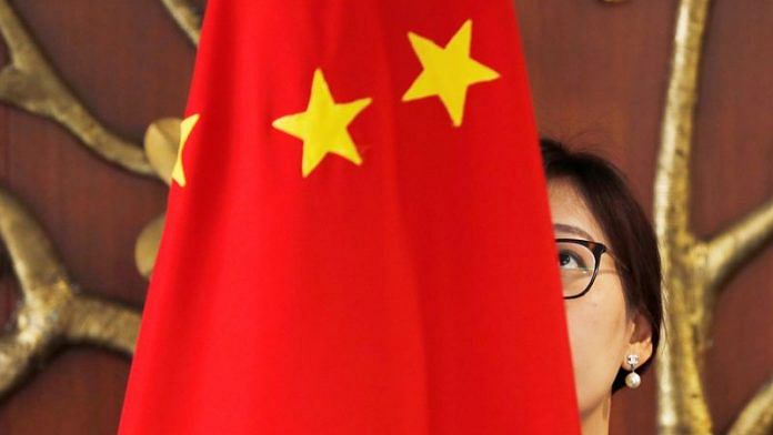 A Chinese official adjusts a Chinese flag before the start of a meeting between Foreign Minister Wang Yi and Indian Foreign Minister Sushma Swaraj in New Delhi | File Photo: Reuters