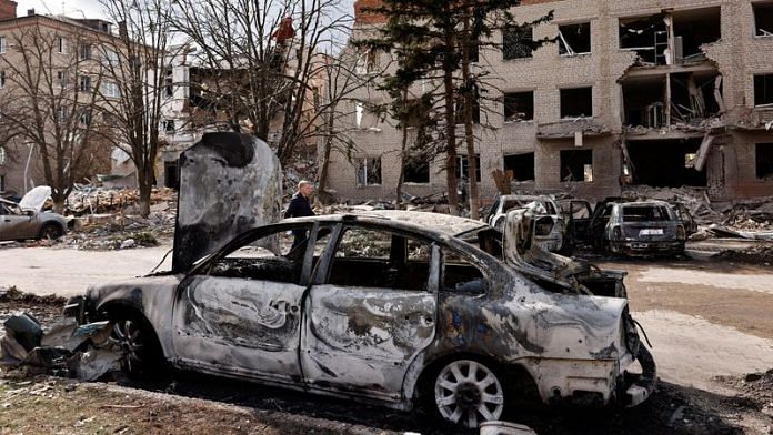 A person walks next to a damaged car in the aftermath of deadly shelling of an army office building, amid Russia's attack, in Sloviansk, Ukraine | File Photo: Reuters