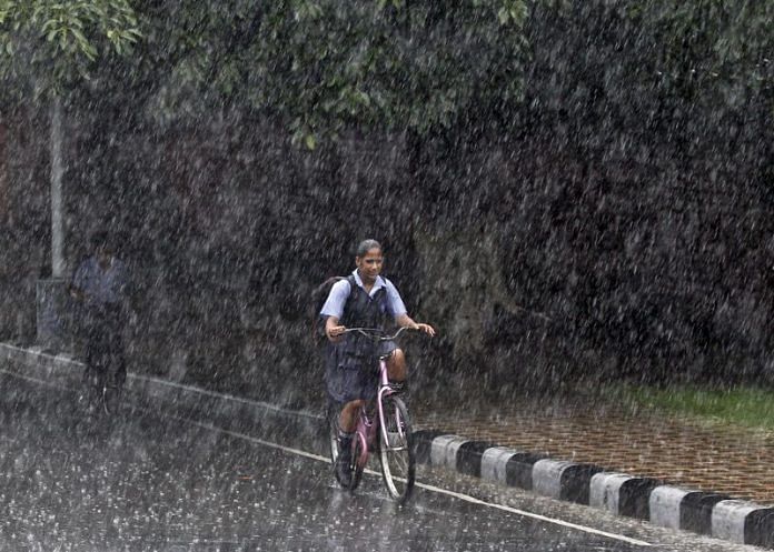 A schoolgirl rides a bicycle on her way back home during a heavy rain shower in Chandigarh | Reuters file photo