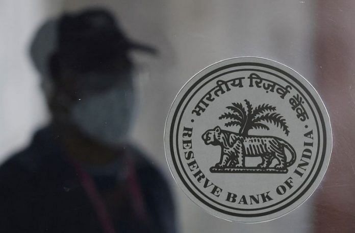 A man walks behind the Reserve Bank of India (RBI) logo inside its headquarters in Mumbai | Reuters file photo