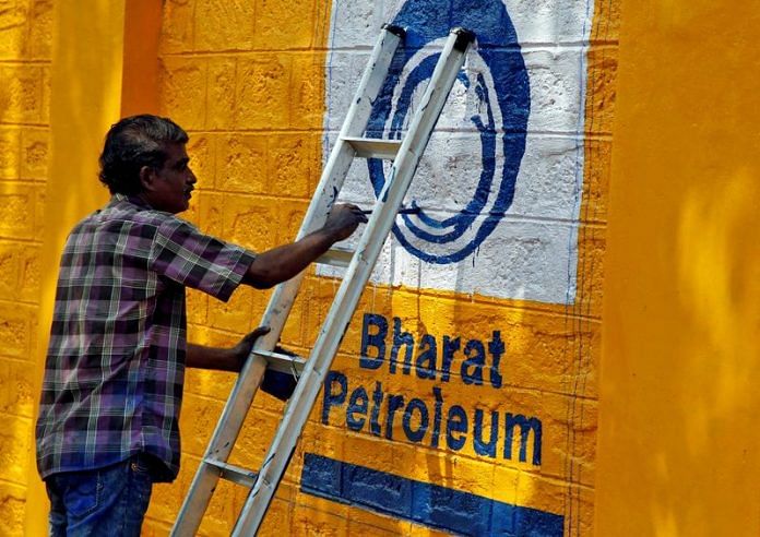 A man paints the logo of oil refiner Bharat Petroleum Corp (BPCL) on a wall | Reuters