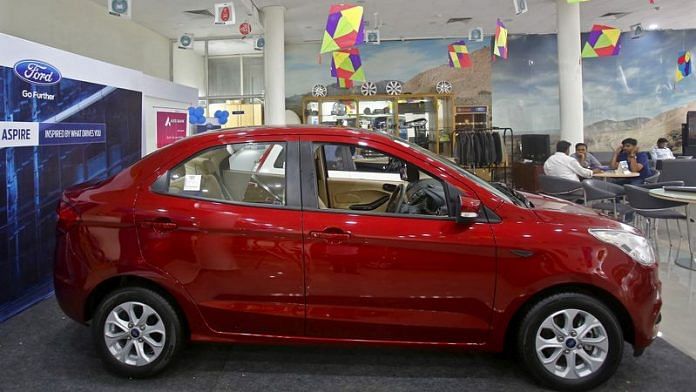 Customers sit near Ford's new Figo Aspire car on display at a showroom in New Delhi | File Photo: Reuters