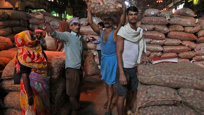 A labourer carries a sack of onions at a wholesale market in Kolkata | File Photo: Reuters