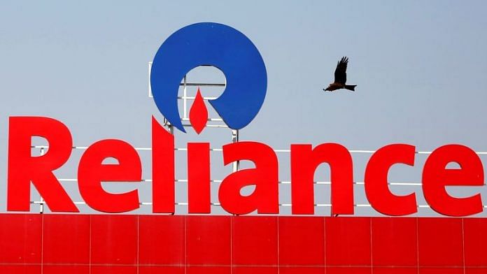 A bird flies past a Reliance Industries logo installed on its mart in Ahmedabad | File Photo: Reuters