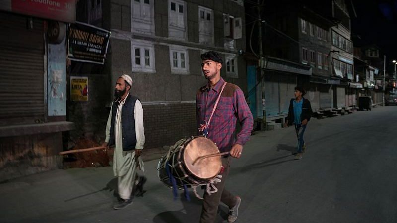 Arif Ahmad Jinded, 18, a Kashmiri Ramadan drummer locally known as "Sahar Khan", is accompanied by his father Abdul Kareem Jinded and brother Imran Jinded as he beats his drum to wake Muslims up for their meal before daybreak in Srinagar on 16 April, 2023 | Reuters