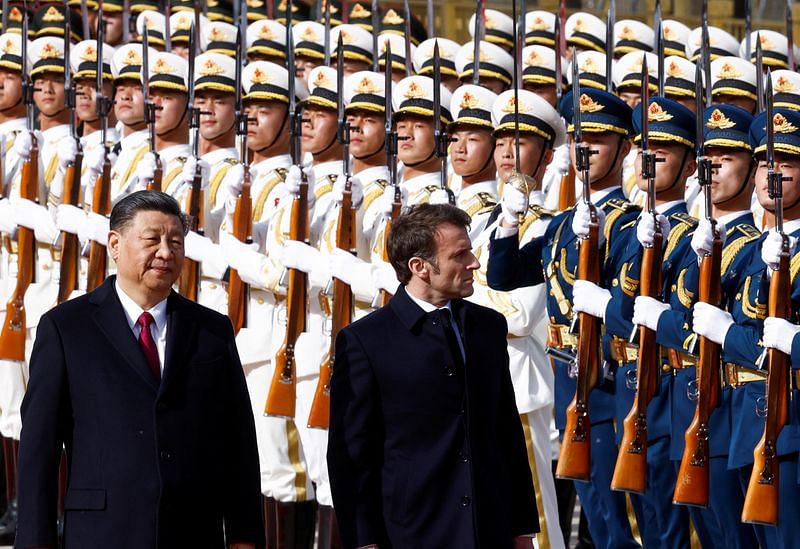 Chinese President Xi Jinping and French President Emmanuel Macron review troops during an official ceremony at the Great Hall of the People, in Beijing, on 6 April 2023 | Reuters