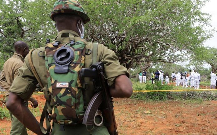 Kenya police officers stand guard as Forensic experts and homicide detectives exhume bodies of the suspected members | Reuters