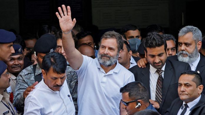 Rahul Gandhi waves as he leaves a court after he lodged an appeal against his conviction for defamation, in Surat on 3 April 2023 | Photo: Reuters