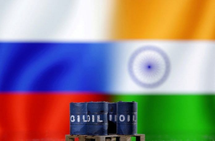 A model of oil barrels is seen in front of Russian and Indian flags in this illustration | Reuters