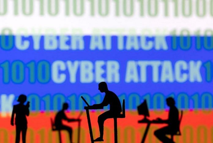 Figurines with computers and smartphones are seen in front of the words 'Cyber Attack', binary codes and the Russian flag, in this illustration | Reuters