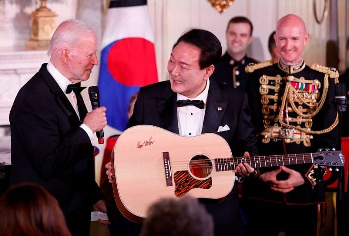 US President Joe Biden gifts a guitar signed by artist Don McLean to South Korea's President Yoon Suk Yeol at an official State Dinner at the White House in Washington, on 26 April 2023 | Reuters