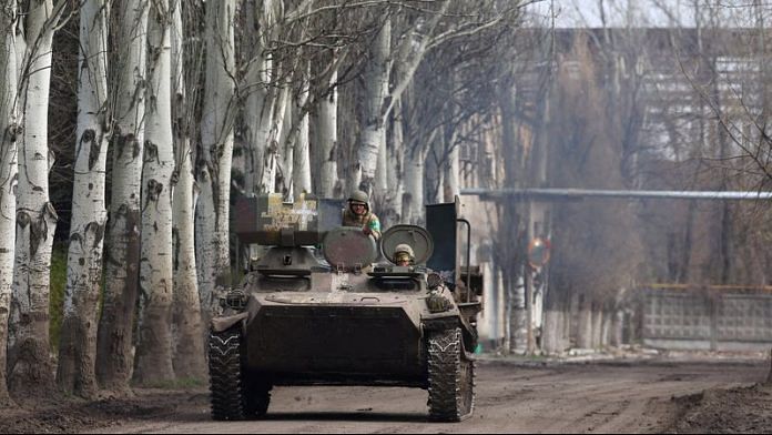 An armoured military vehicle speeds through Chasiv Yar during heavy fighting at the fronttline of Bakhmut and Chasiv Yar, Ukraine, on 9 April, 2023 | Reuters