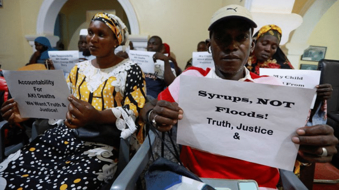 Grieving parents hold up signs during a news conference, calling for justice for the deaths of children linked to contaminated cough syrups, in Serekunda, Gambia | Reuters file photo/Edward McAllister
