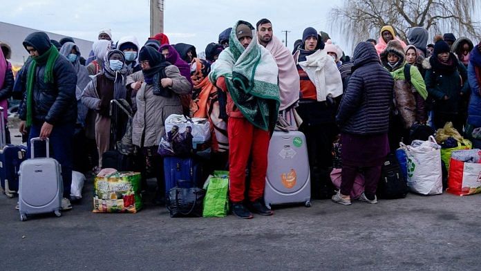 People who have fled the Russian invasion in Ukraine wait to board a bus bound for a refugee centre established in Przemysl, in Medyka, Poland | Reuters file photo