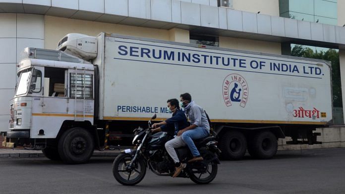 Men ride on a motorbike past a supply truck of Serum Institute, the world's largest maker of vaccines, in Pune | Reuters file photo