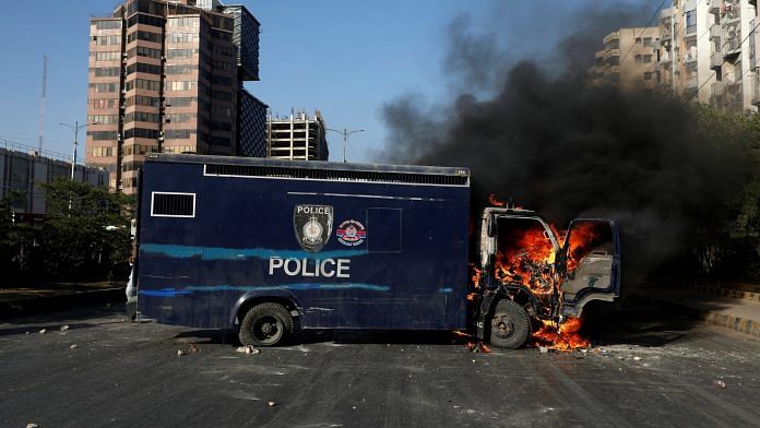 A police vehicle burns during a protest by the supporters of Pakistan's former Prime Minister Imran Khan after his arrest, in Karachi, Pakistan on 9 May, 2023 | Reuters