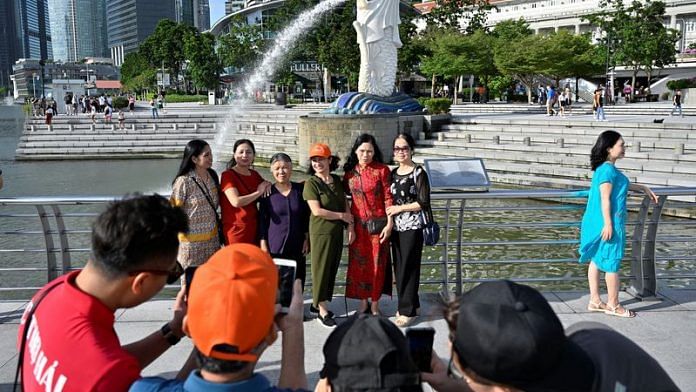Tourists pose for photographs at Merlion Park in Singapore | File Photo: Reuters