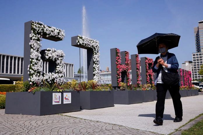 A woman walks past a “G7 Hiroshima” flower installation near the Peace Memorial Museum, ahead of the G7 summit, in Hiroshima, on 17 May 2023 | Reuters