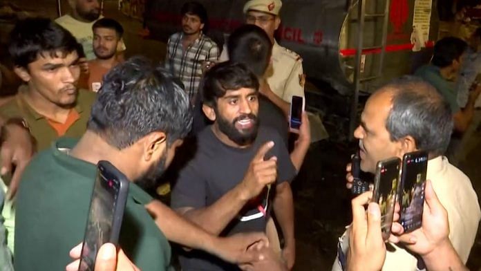 Wrestler Bajrang Punia speaks to a police officer after a scuffle broke out at Jantar Mantar in New Delhi Wednesday | ANI