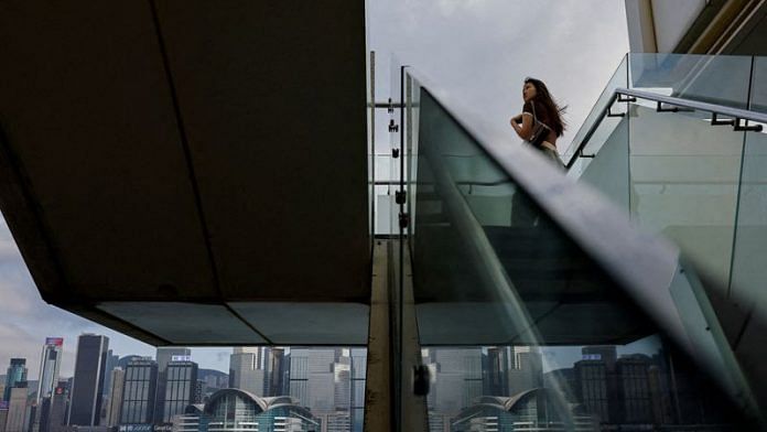 A mainland Chinese tourist looks out at the skyline of buildings at Tsim Sha Tsui, in Hong Kong, China on 2 May, 2023 | Reuters