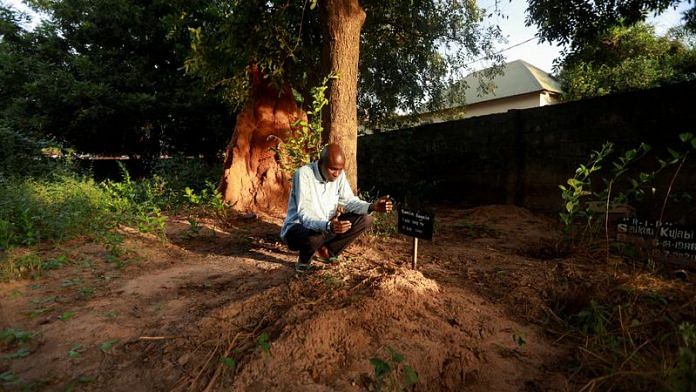 Ebrima Sagnia prays at the graveside of his 3-year-old son Lamin in Old Yundum, Gambia, on 1 November, 2022 | Reuters