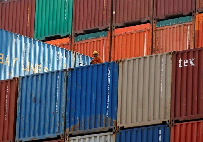 A worker sits on a ship carrying containers at Mundra Port in the western Indian state of Gujarat | Reuters